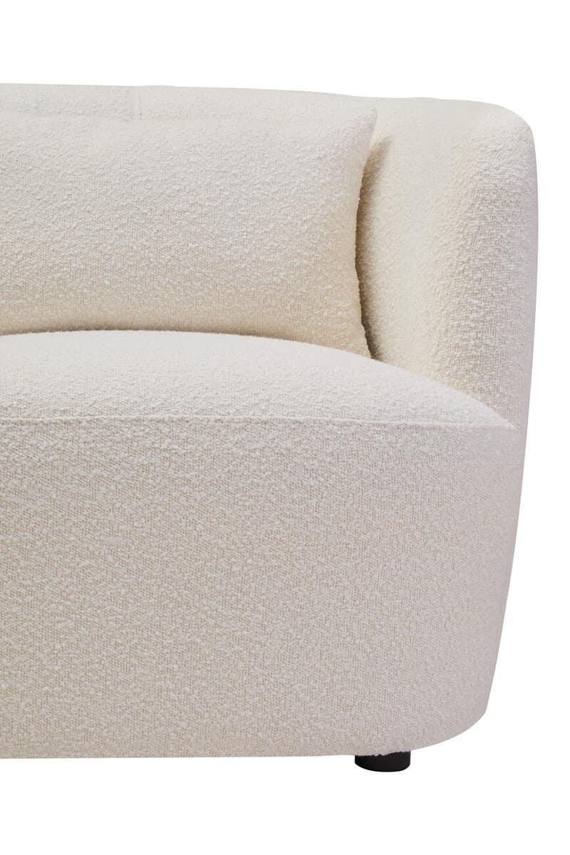 Curved cream fabric sofa with textured upholstery and matching cushion, front side view