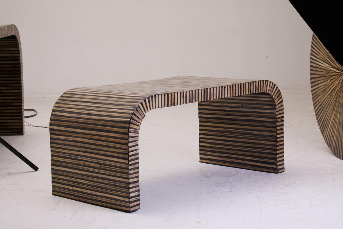 Modern striped wood bench with curved sides on white studio floor