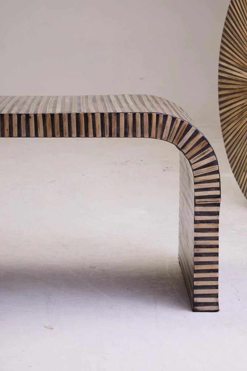 Striped wood bench with curved legs on a light floor, modern minimalist furniture design