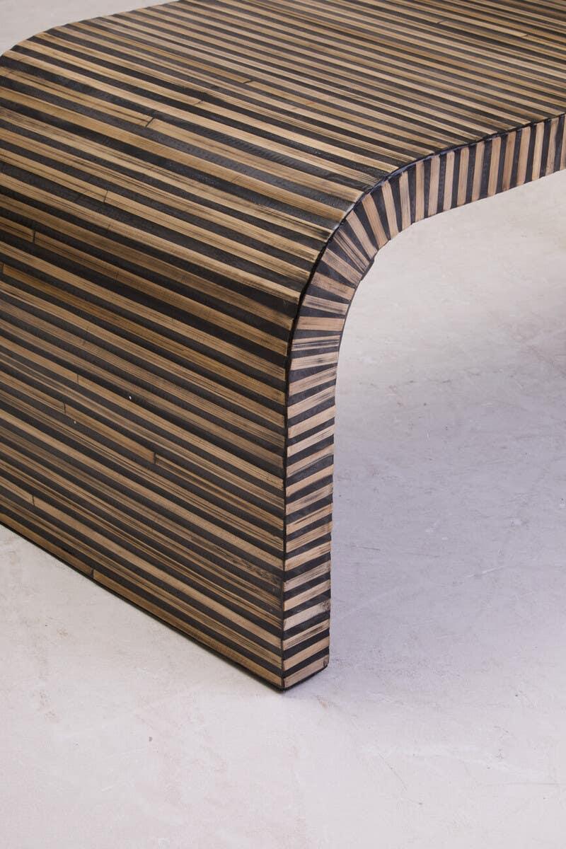 Striped wood coffee table with curved edge on light floor
