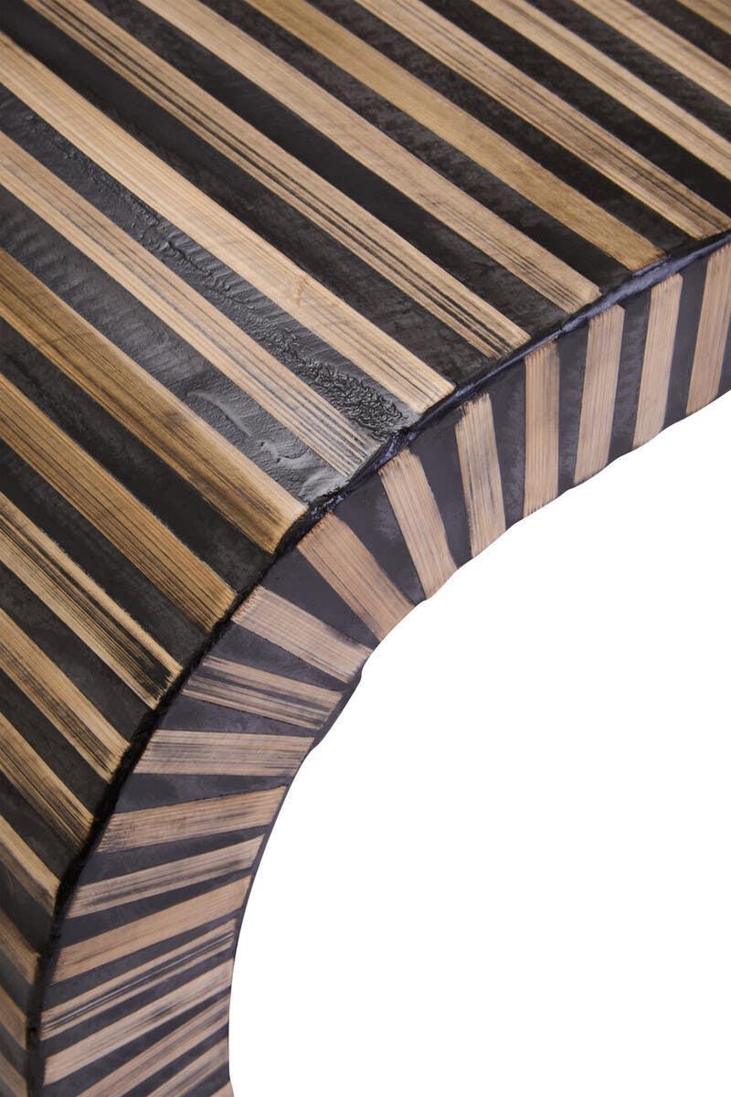 Closeup of striped wooden furniture edge with black and natural wood finish