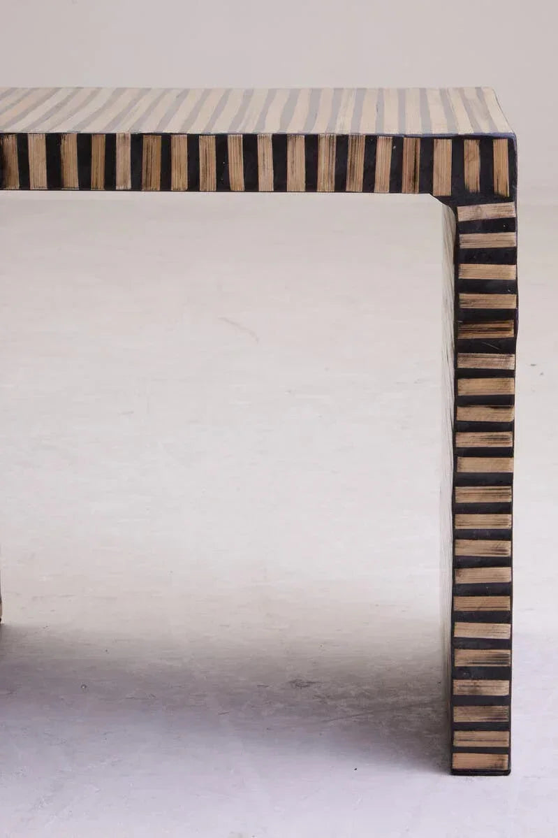 Striped wood console table corner with black and natural finish on white background