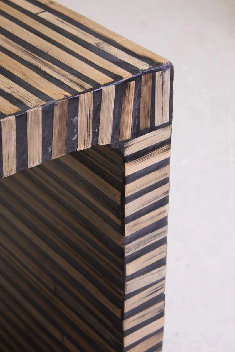Striped wood and black accent side table, close view of corner and surface texture