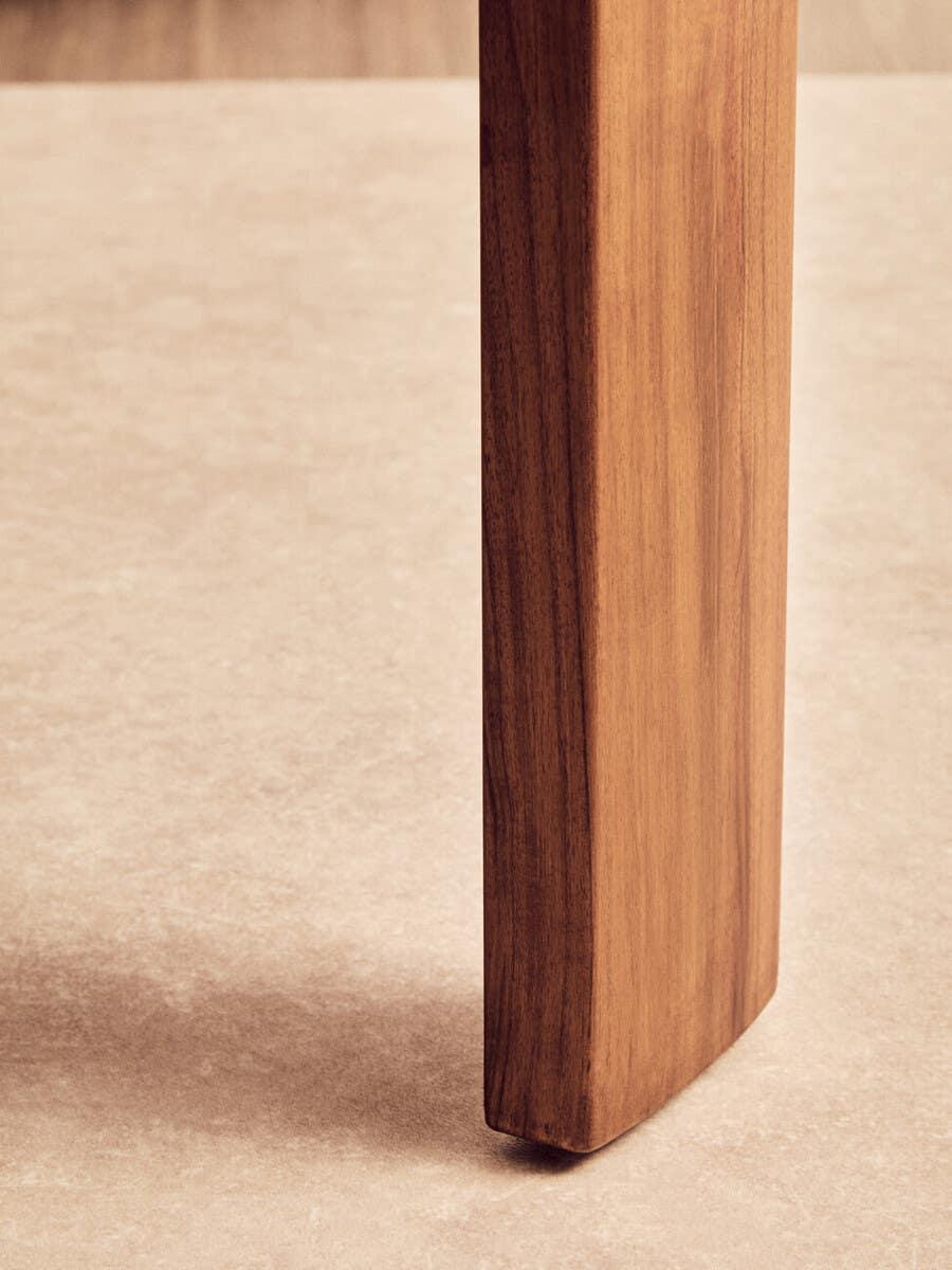 Closeup of wooden furniture leg with natural grain on light tile floor