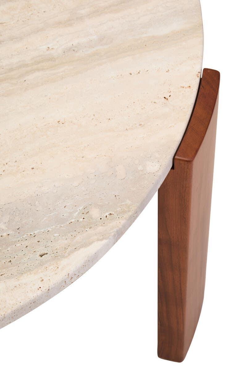 Closeup of round stone coffee table with beige travertine top and wooden leg