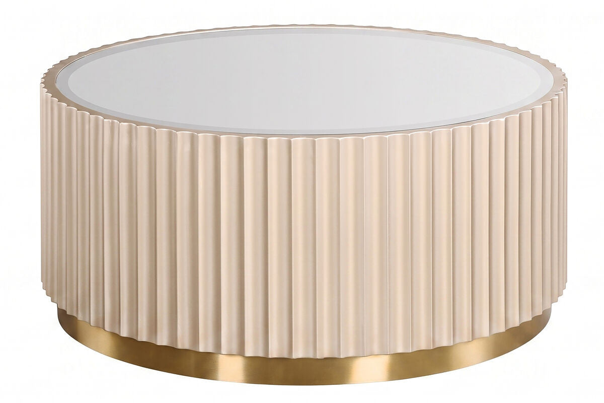 Round coffee table featuring a fluted design in a soft beige color, complemented by a sleek mirrored top. The base is adorned with a shiny gold trim, adding a touch of elegance.