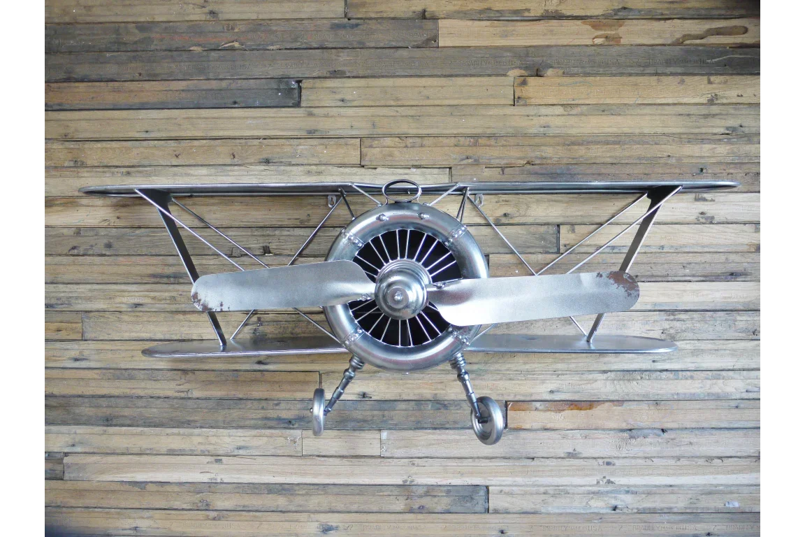 metal biplane wall art with propeller on wooden background