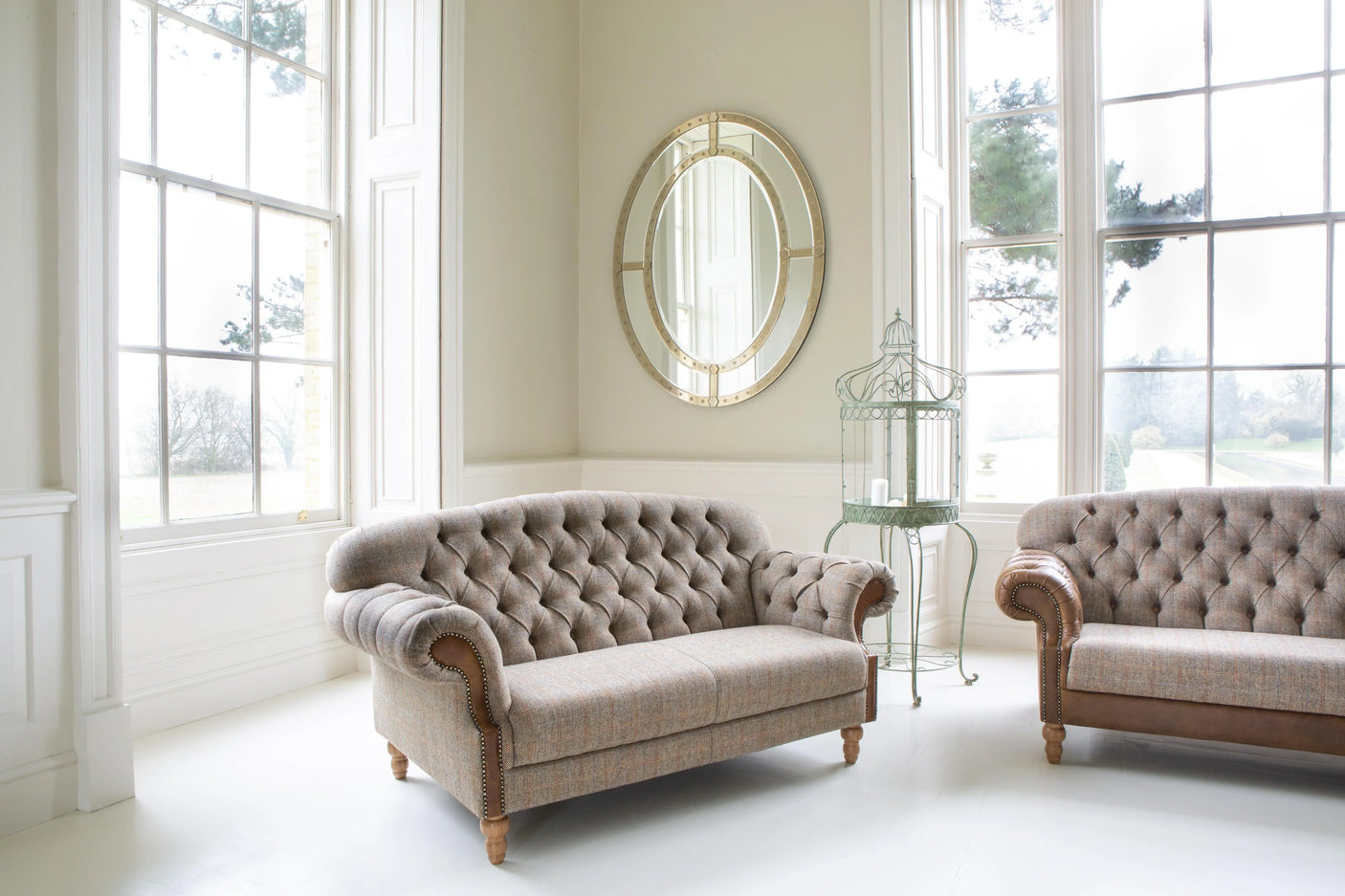 Button tufted fabric sofas with rolled arms and wood legs in bright living room