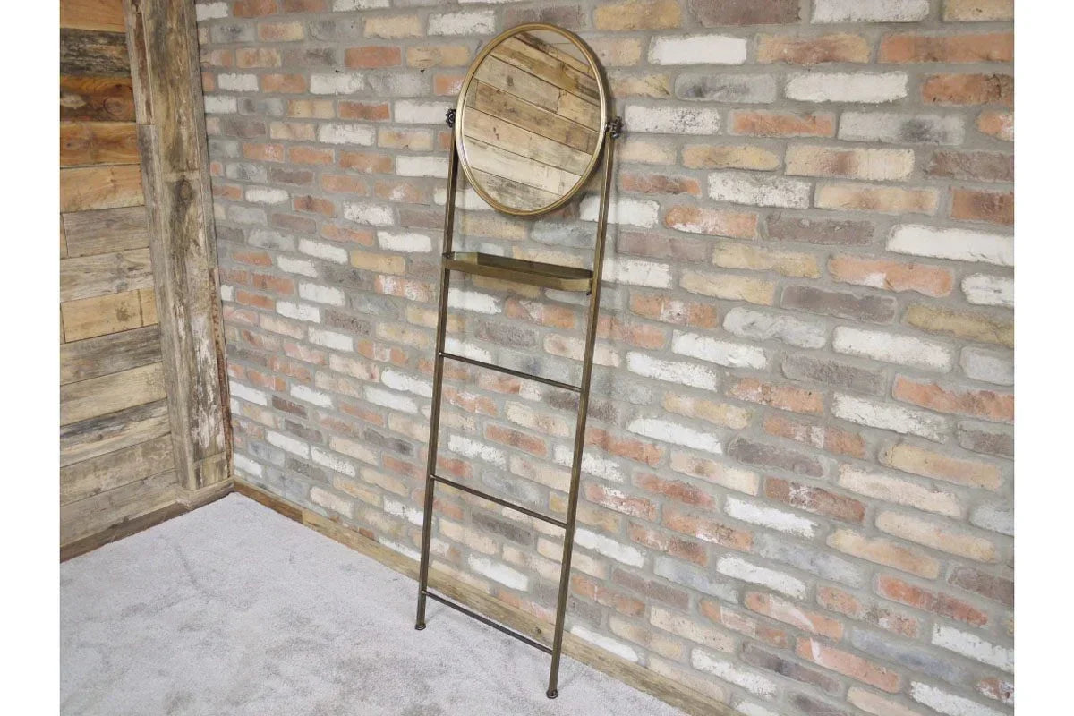 Metal frame ladder mirror with shelf leaning against exposed brick wall