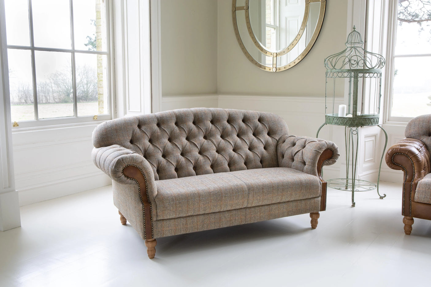 Grey tufted fabric sofa with wooden legs in bright living room