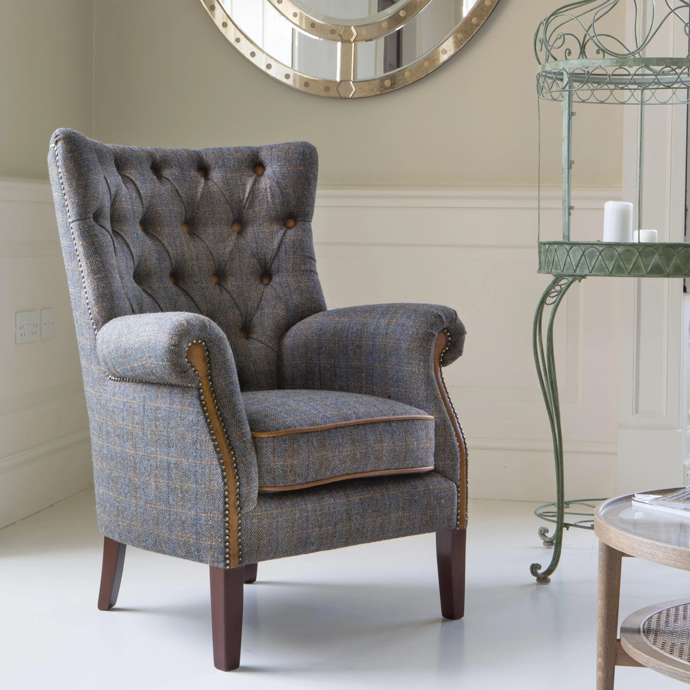 Grey tweed armchair with button-tufted back and wooden legs in a living room setting