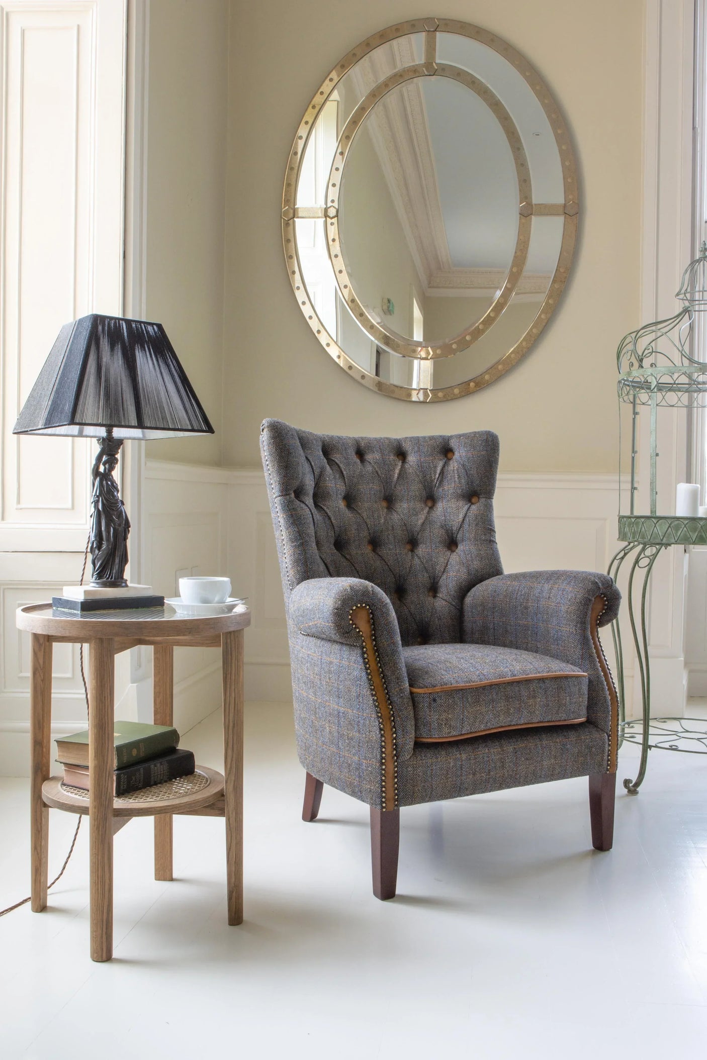 Upholstered armchair with button-tufted back beside wooden side table and lamp in living room