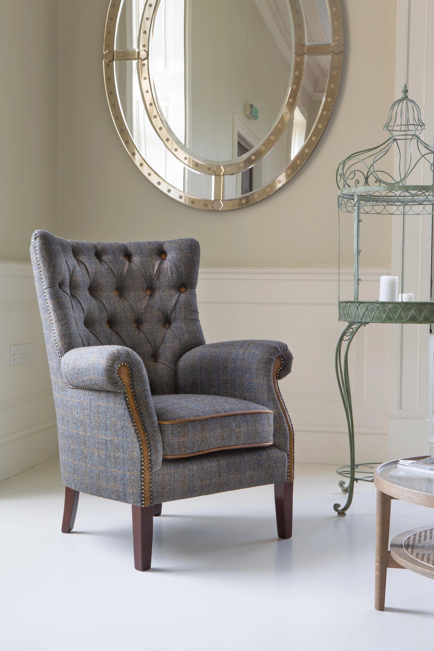 Grey tweed armchair with button-tufted back and wooden legs in a modern living room