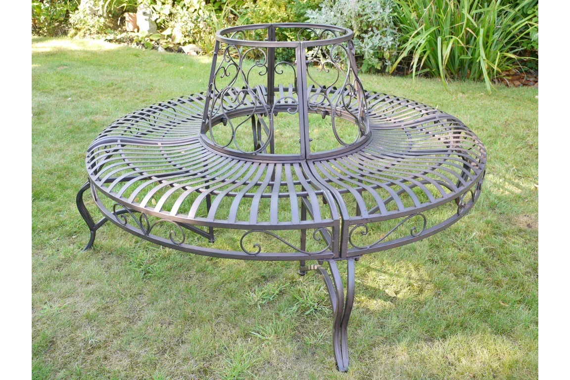 Metal garden tree bench with curved seat and decorative scrollwork on lawn