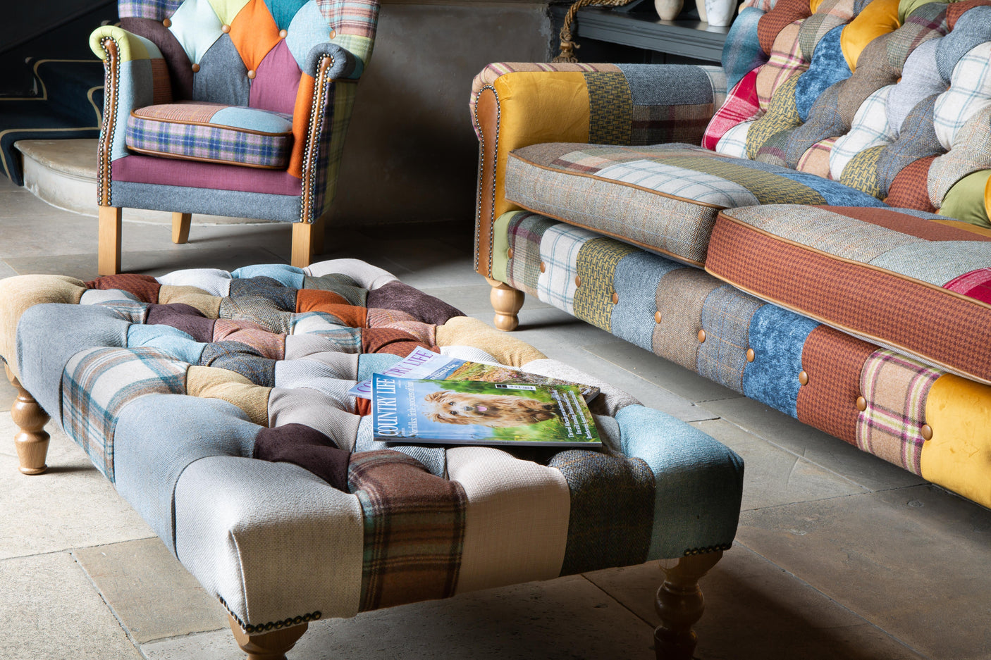 Patchwork fabric armchair, sofa and ottoman with wooden legs in living room setting