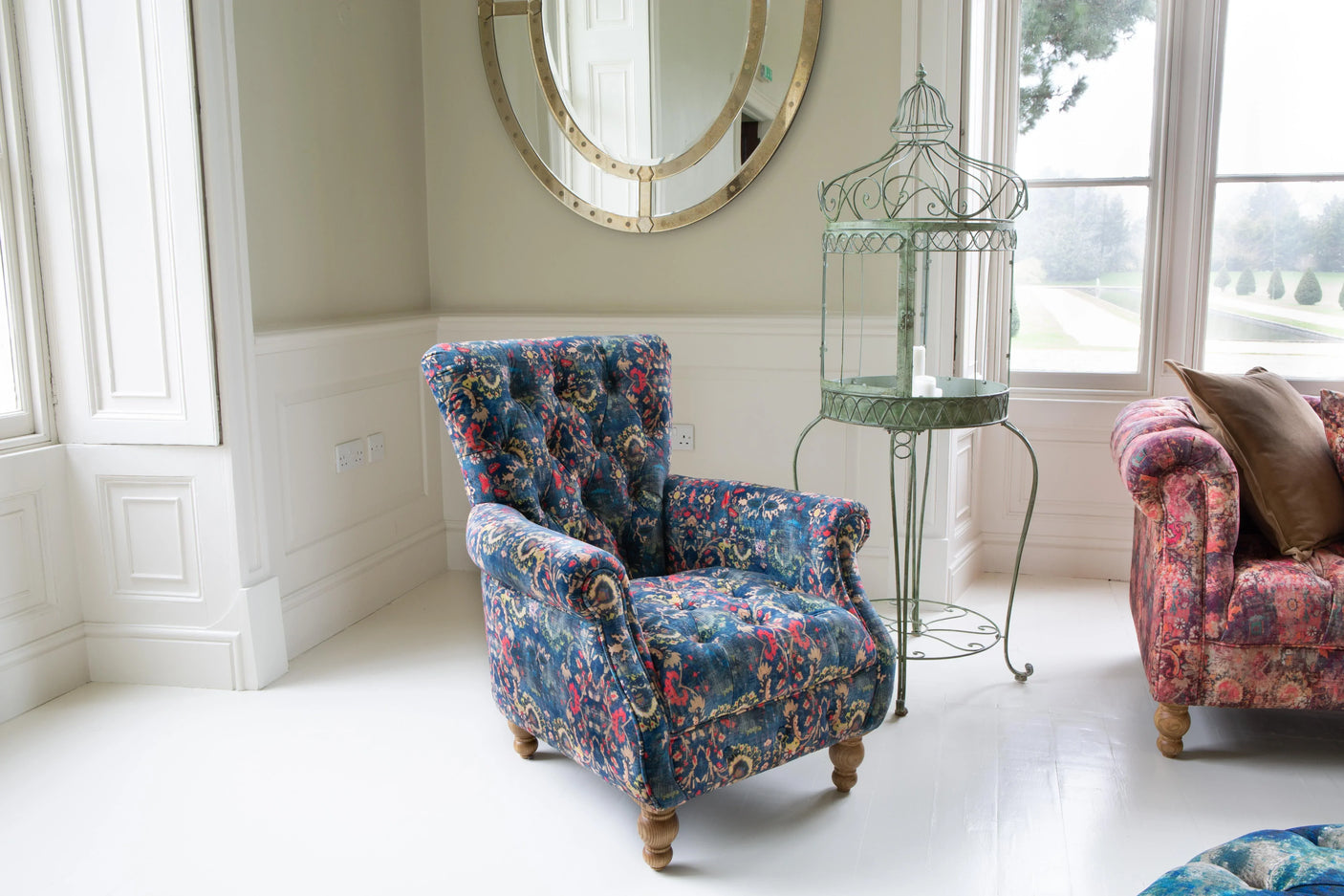 Blue floral patterned armchair with wooden legs in bright living room