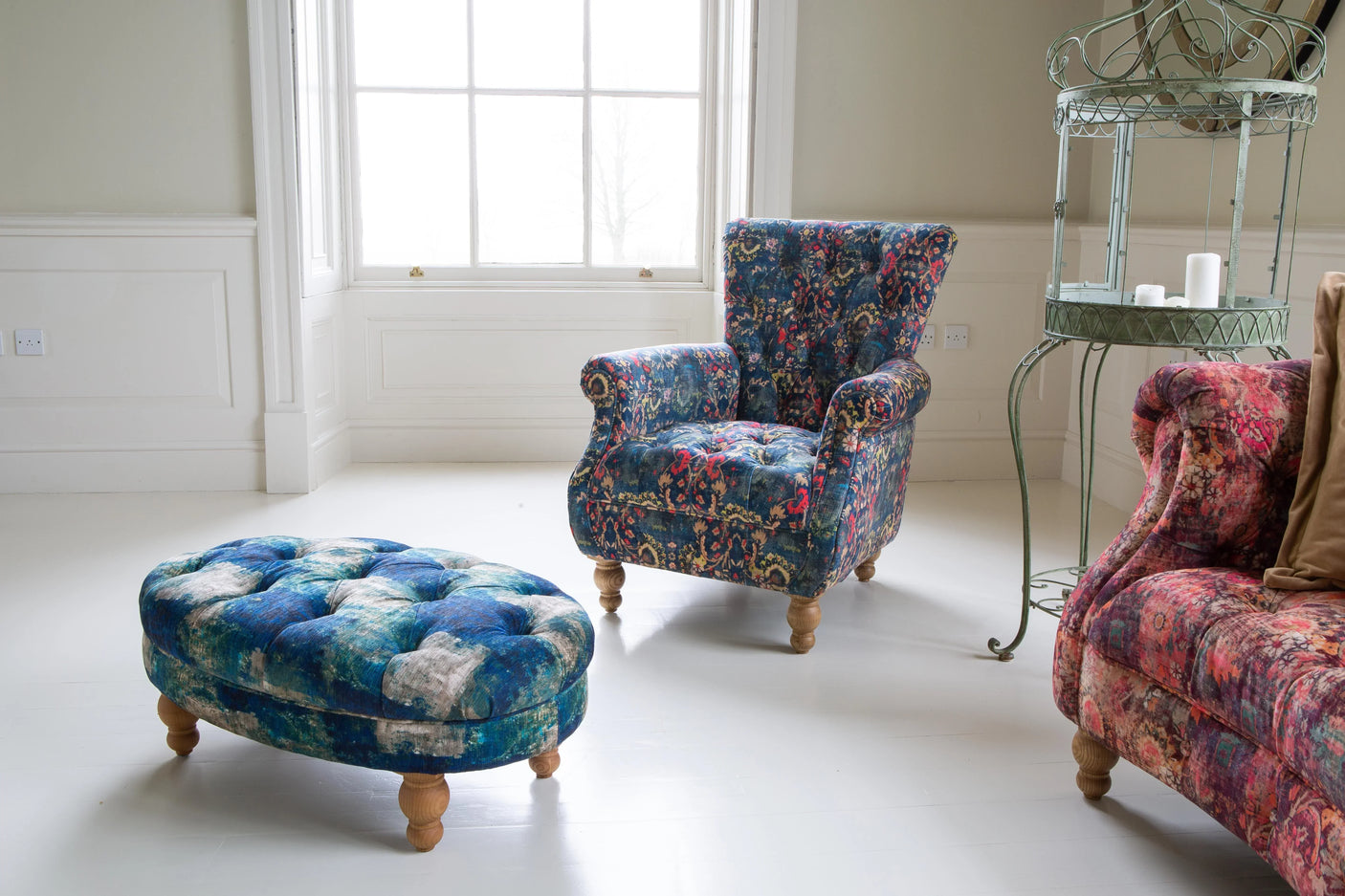 Blue patterned armchair and ottoman with wooden legs in bright living room setting