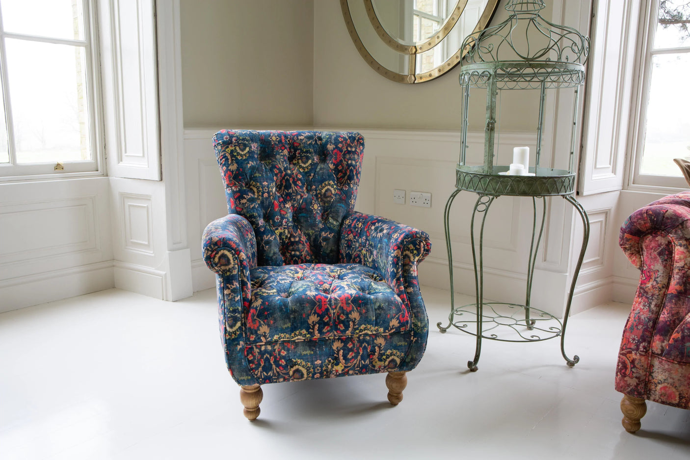 Patterned blue fabric armchair with wooden legs in bright living room