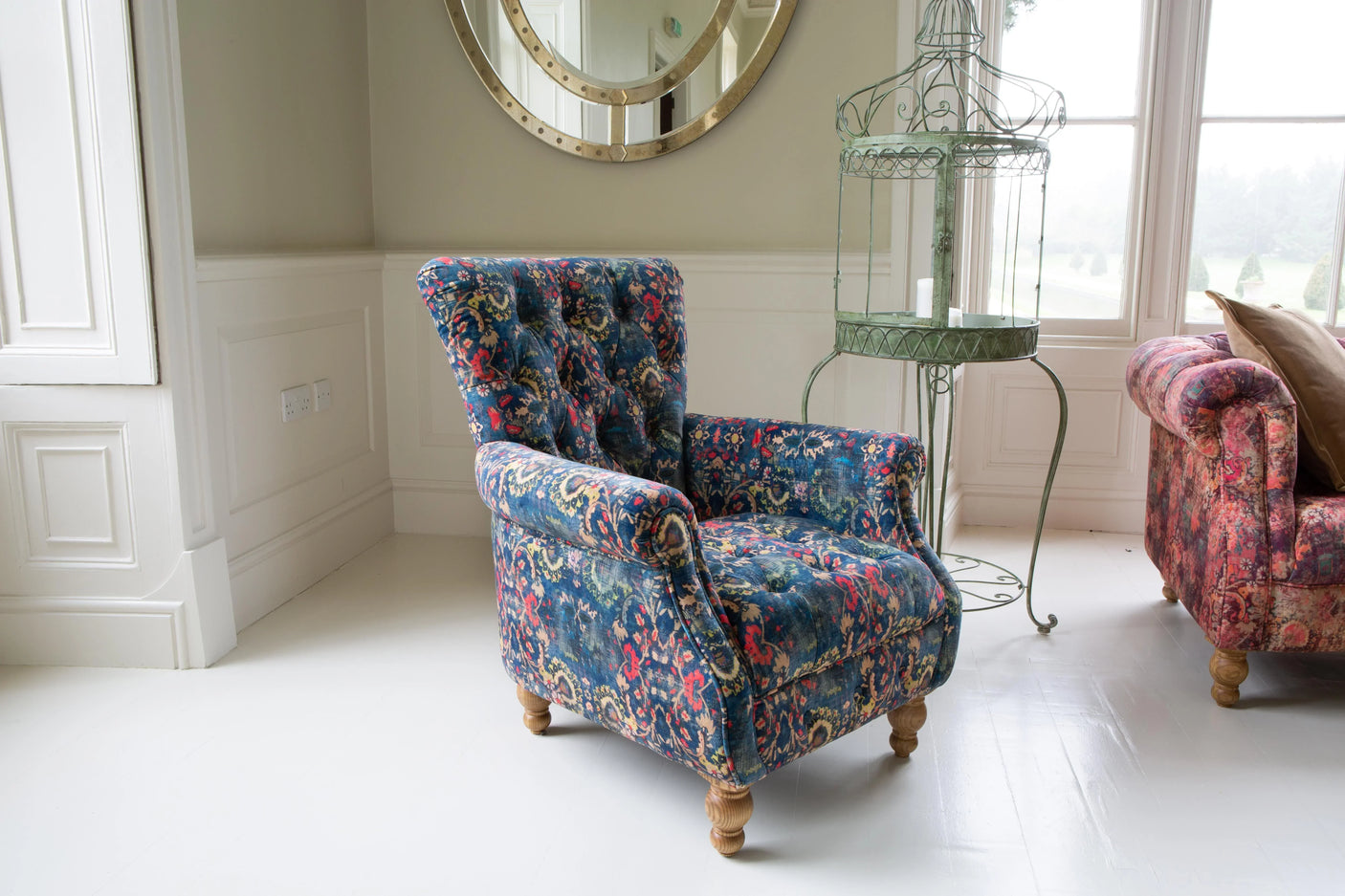 Patterned fabric armchair with wooden legs in bright lounge setting