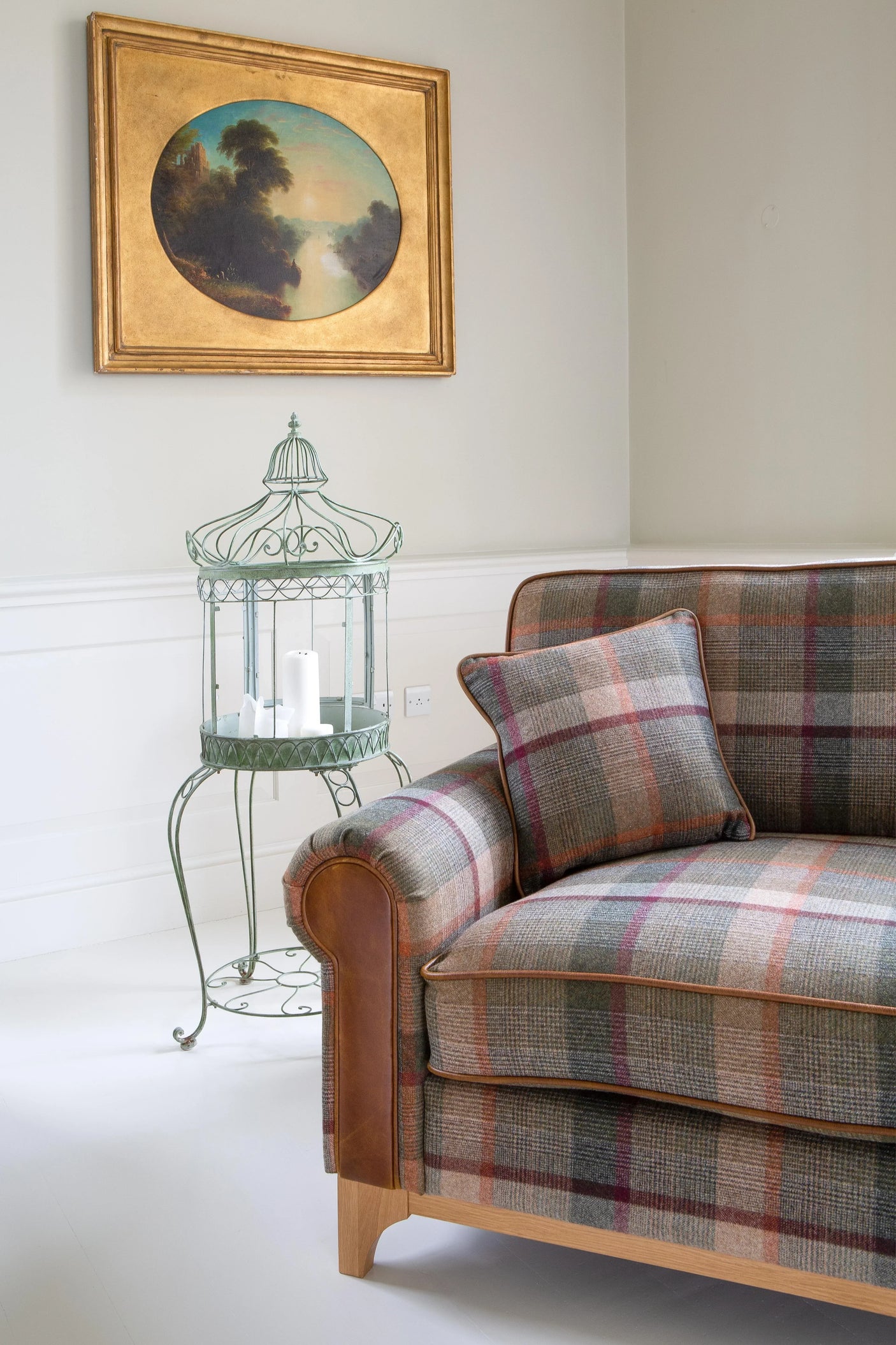 Plaid fabric sofa with leather arm trim and matching cushion in modern living room corner