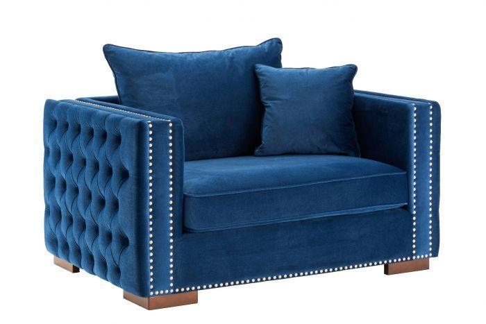 Blue velvet armchair with stud detailing, tufted sides, and wooden legs