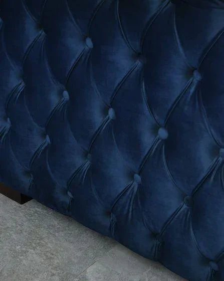 Navy velvet upholstered sofa with deep button tufting and diamond stitch detail