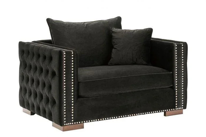 Black velvet armchair with button-tufted sides, silver stud trim, and wooden block feet