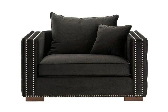 Black velvet armchair with studded trim and two matching cushions, front view