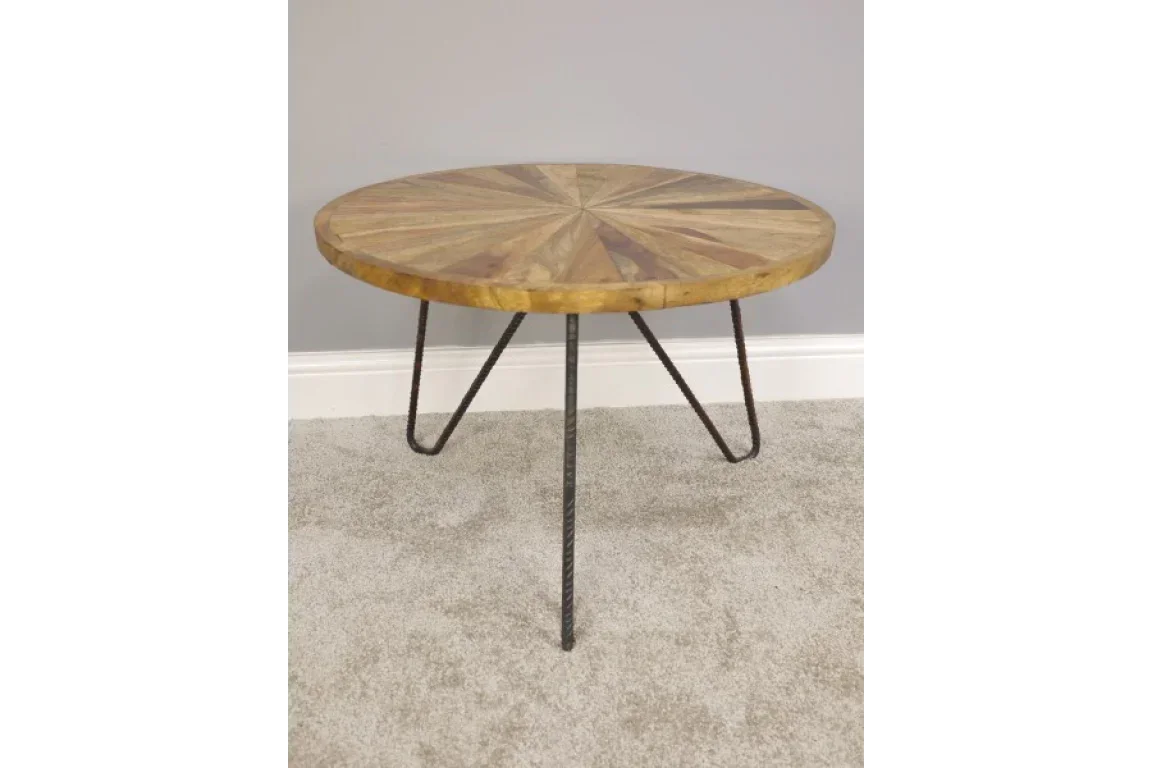 Round wooden coffee table with geometric top and metal hairpin legs on carpeted floor