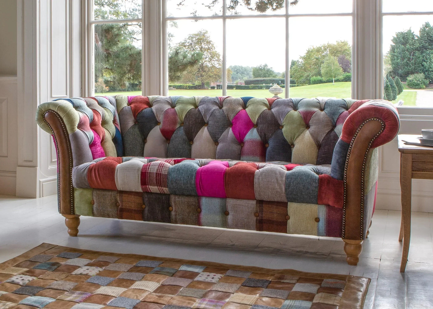Patchwork fabric sofa with wooden legs and button-tufted back in bright living room