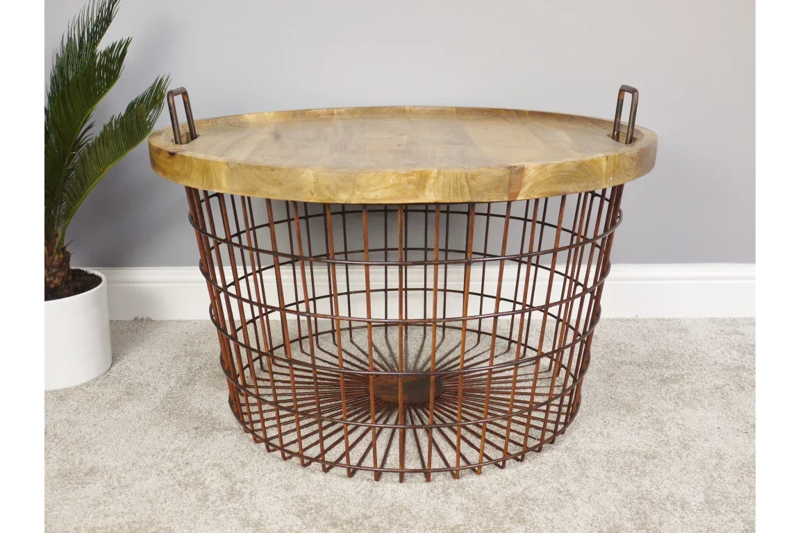 Round wooden coffee table with metal wire base and handles, placed on a light carpet