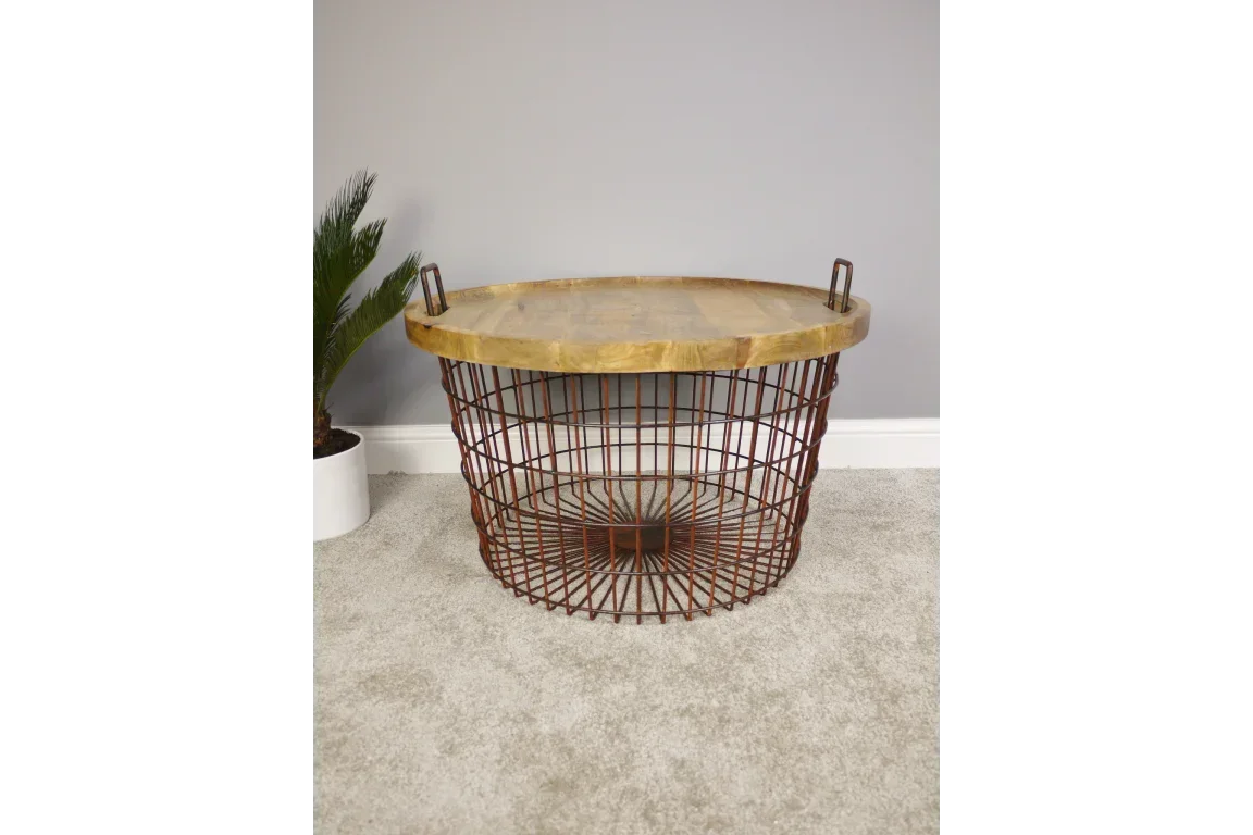 Round wire basket coffee table with wood top and metal handles on carpeted floor
