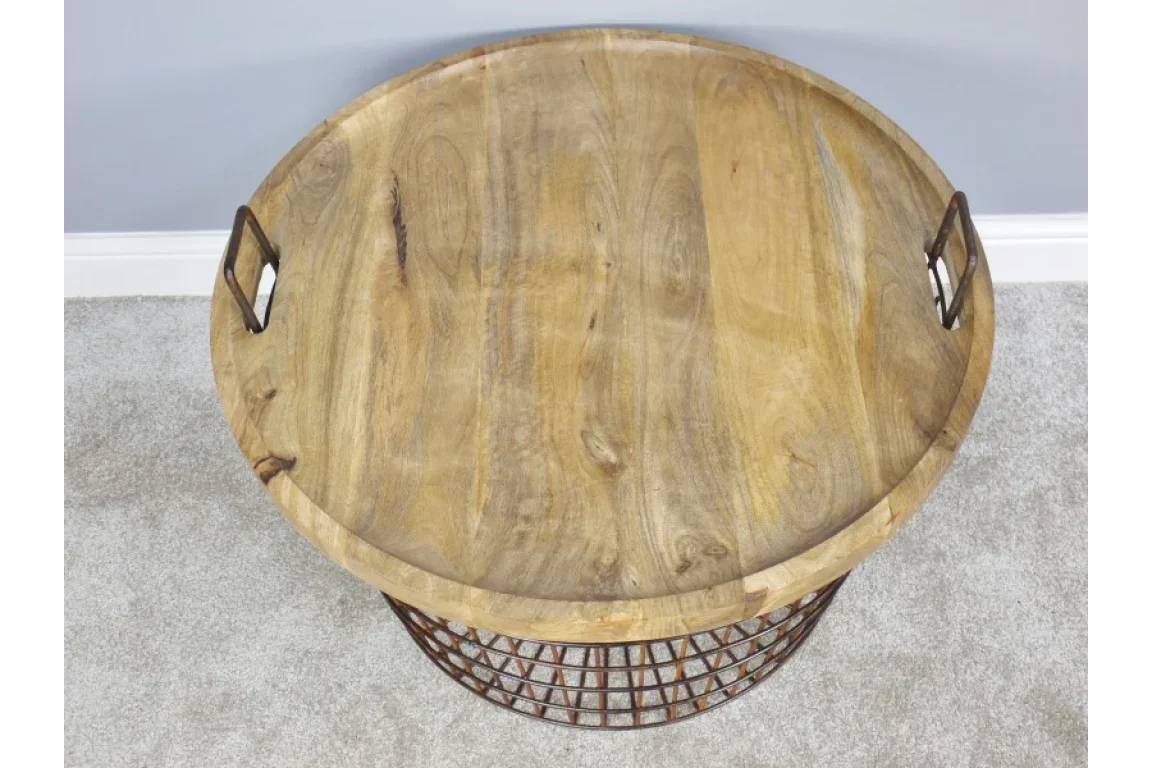 Round wooden coffee table with metal handles and wire basket base on grey carpet