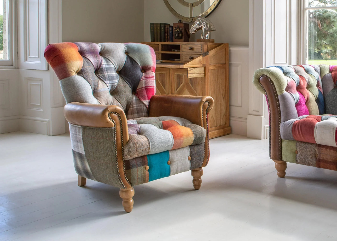 Patchwork fabric armchair with leather arms and wooden legs in bright living room