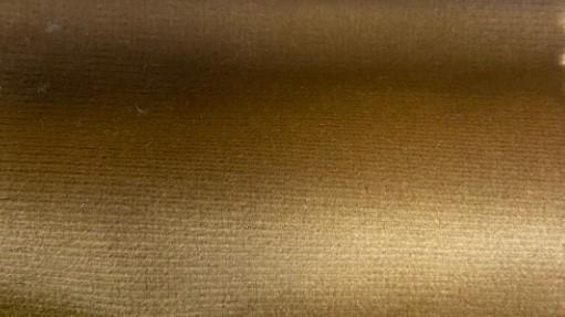Closeup of gold velvet fabric upholstery texture for sofa or chair