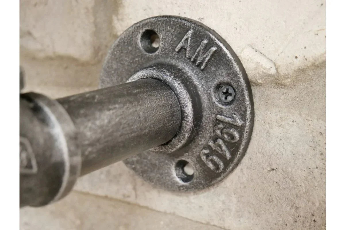 Industrial metal pipe shelf bracket mounted on textured wall