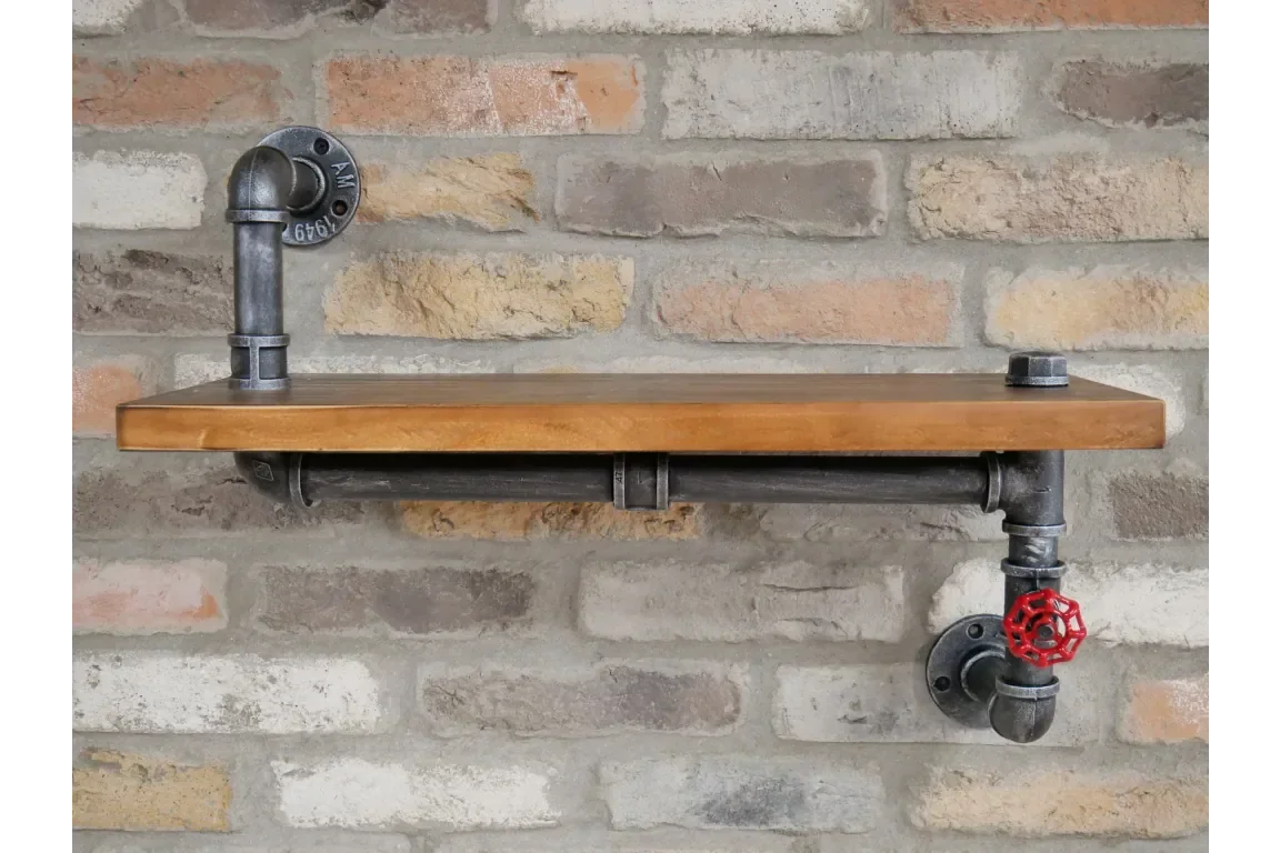 Industrial pipe wall shelf with wood top and red valve detail on brick wall