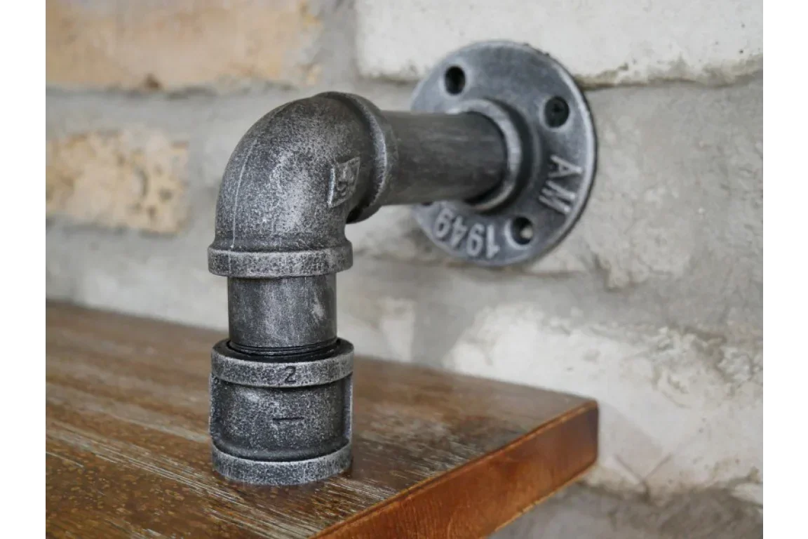 industrial pipe shelf bracket mounted on wall with wooden shelf