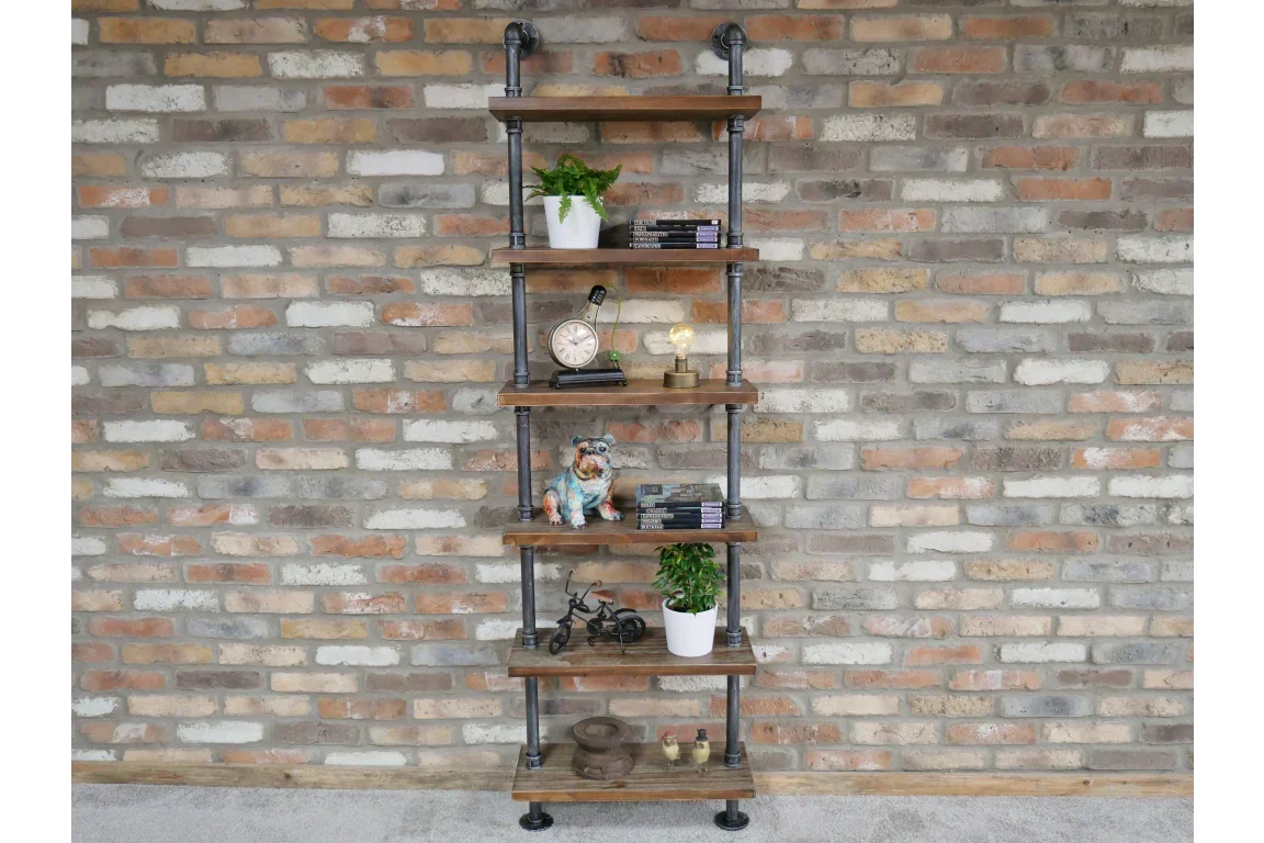 Industrial pipe bookshelf with wooden shelves against brick wall, styled with decor and books