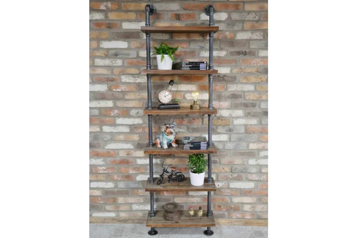 Industrial pipe bookshelf with wooden shelves styled against exposed brick wall