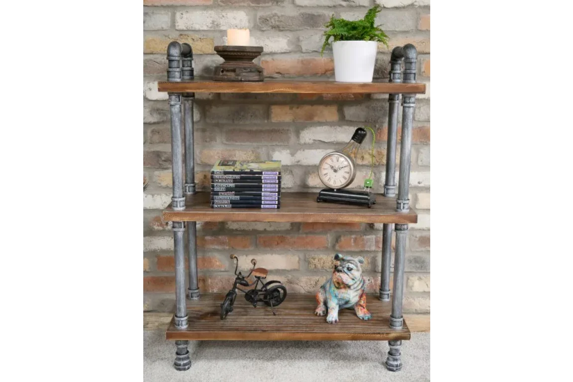 industrial pipe shelving unit with wood shelves styled against brick wall with decor items