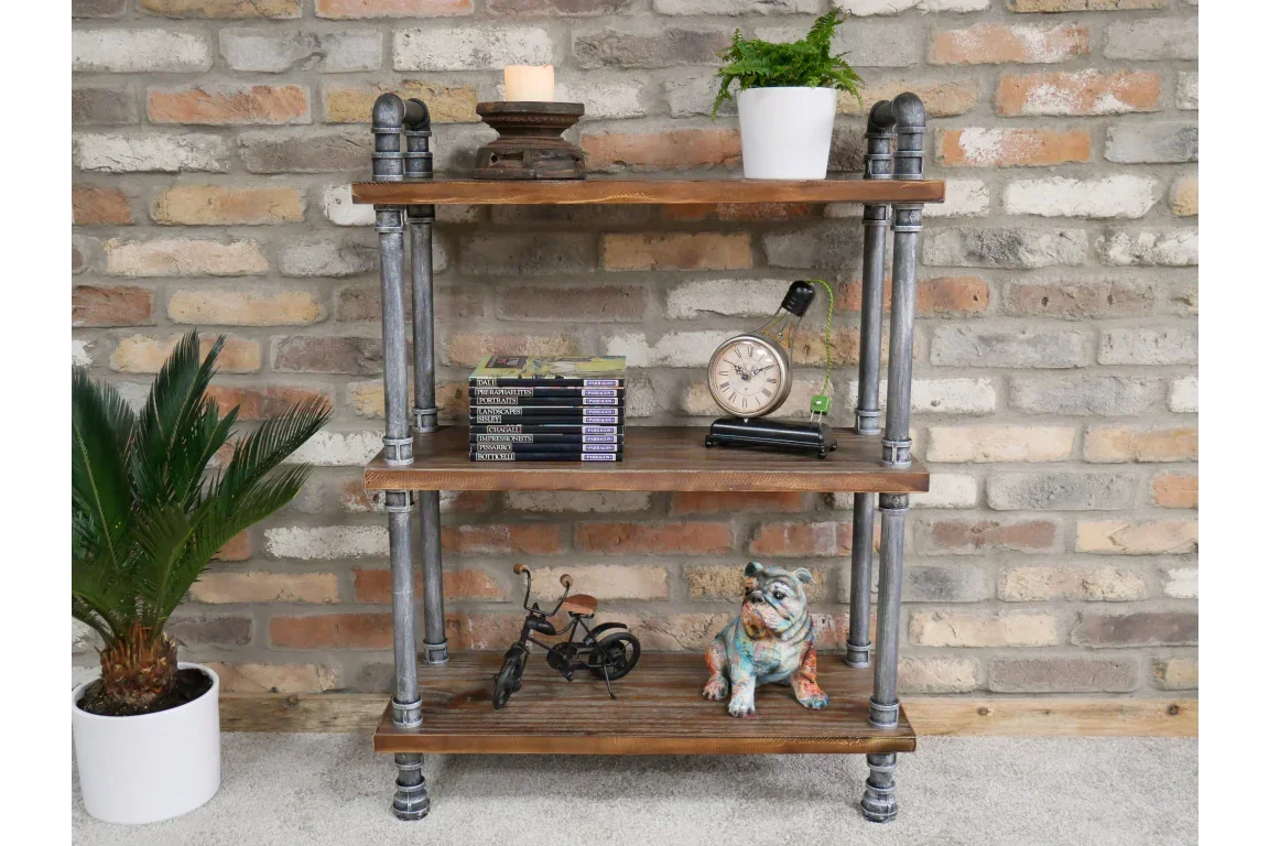 Industrial style wooden shelving unit with metal pipes against brick wall, decorated with plants