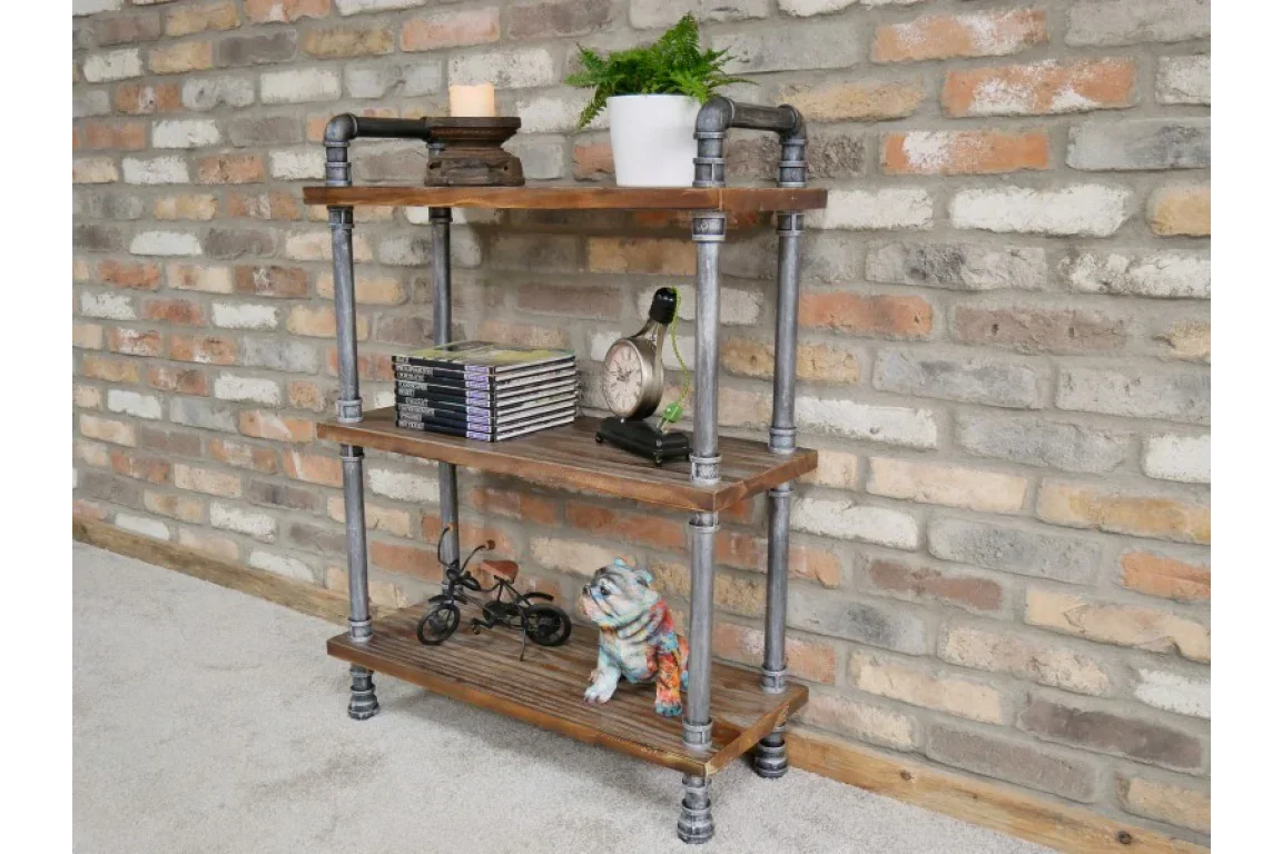 Industrial pipe shelving unit with wooden shelves against exposed brick wall