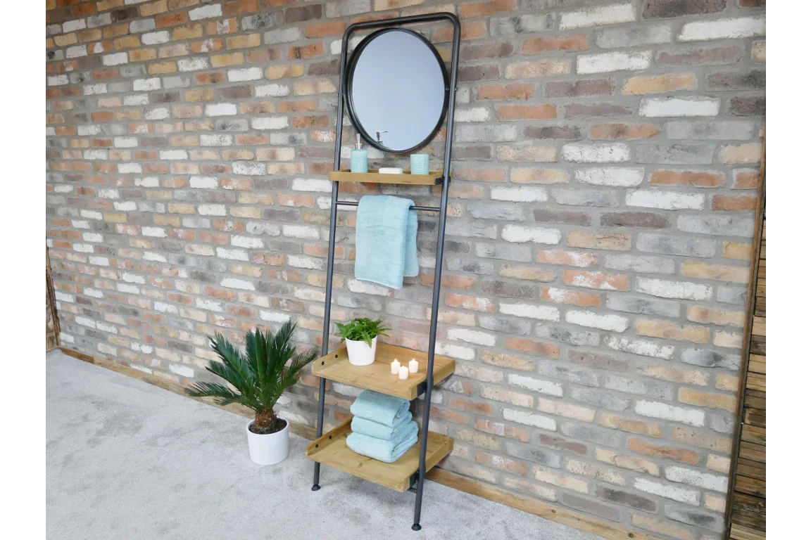 Industrial ladder shelf with round mirror, wooden tiers and towel rail against brick wall