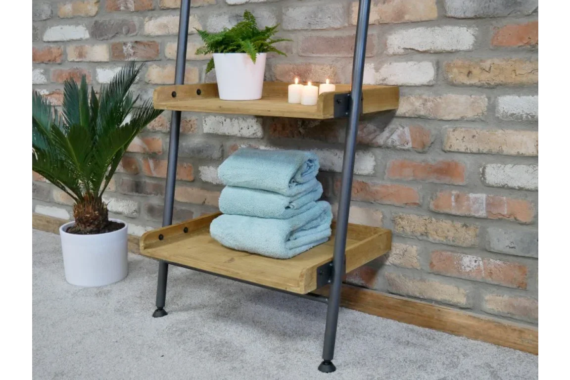 Industrial wooden shelf unit with black metal frame holding towels, candles, and plant