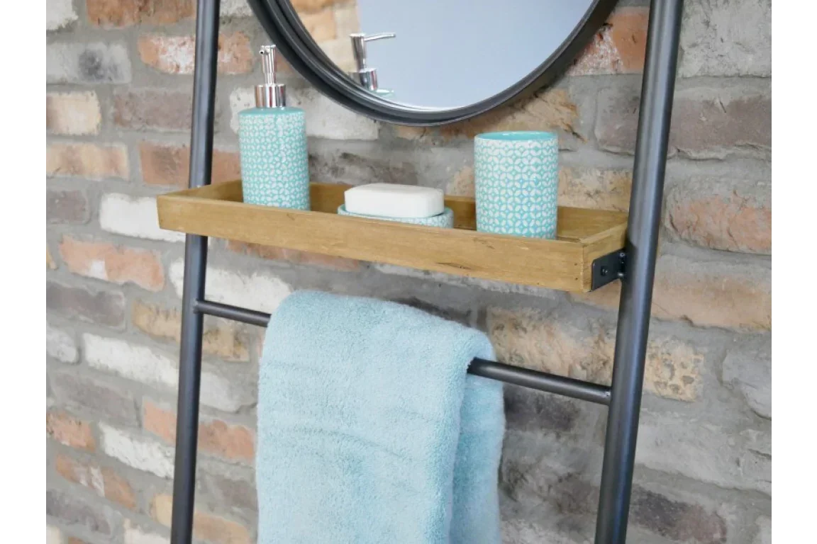 Modern towel ladder with wooden shelf, blue towel, soap dish and accessories against brick wall