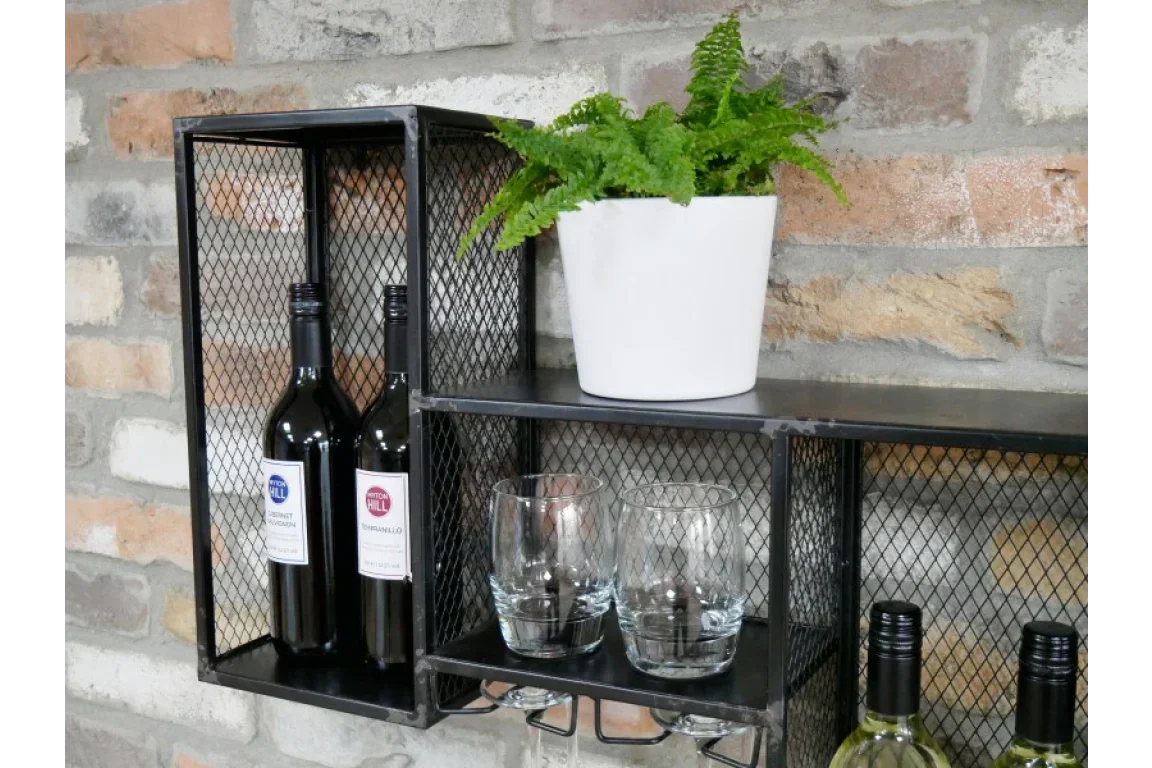 Wall mounted black metal wine rack with glasses and potted plant on exposed brick wall