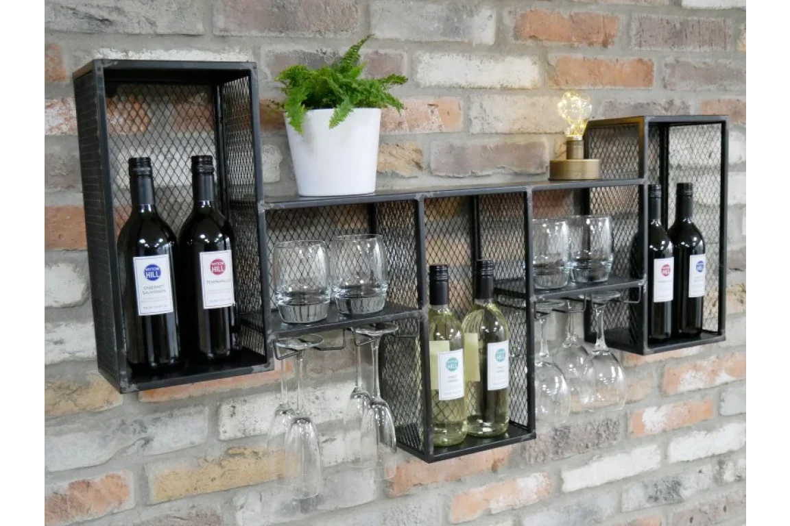 Industrial wall mounted wine rack with metal mesh shelves, bottles, glass holders, and decor