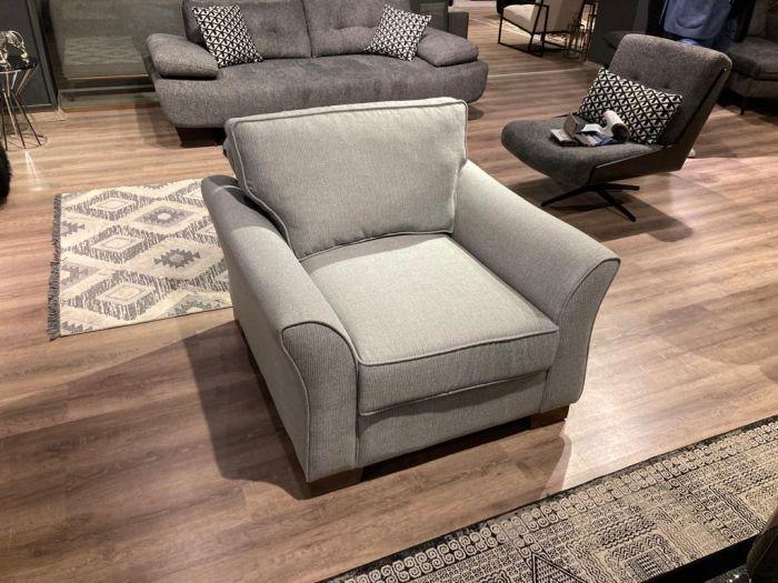 Light grey fabric armchair with wide seat and plush cushions in modern living room setting