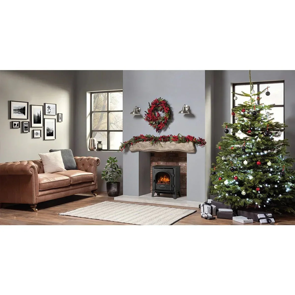 Brown sofa and electric fireplace in festive living room with Christmas tree and decorations